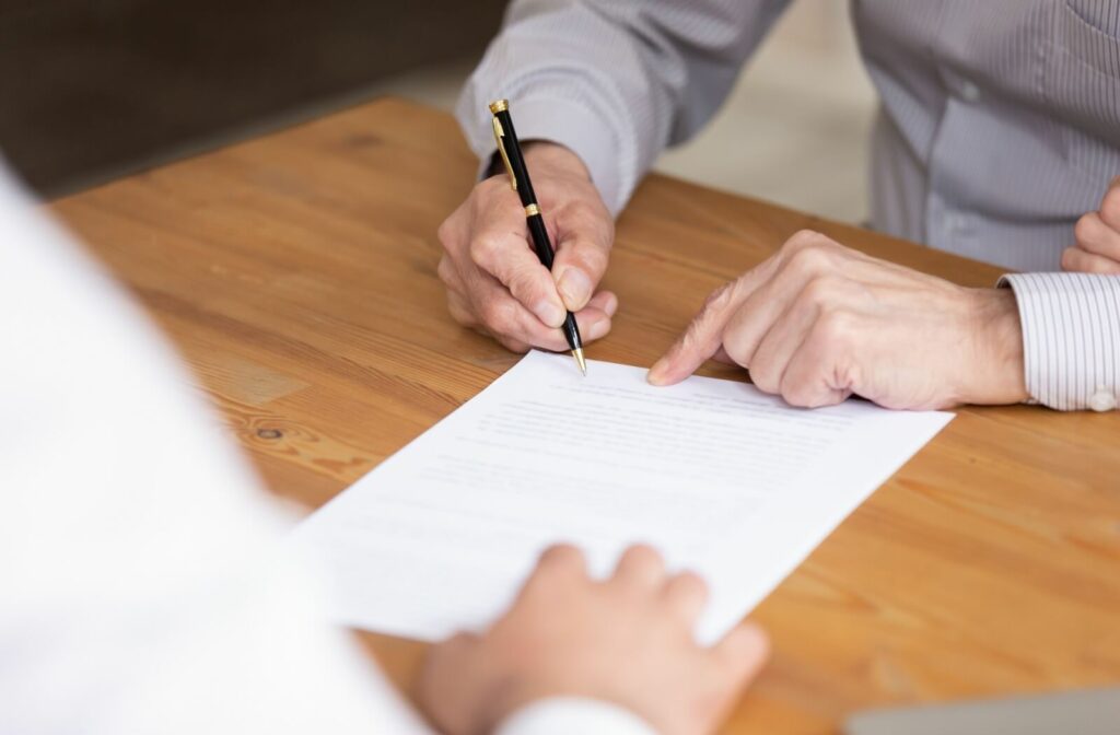 A close up of an older man signing a Power of Attorney document.