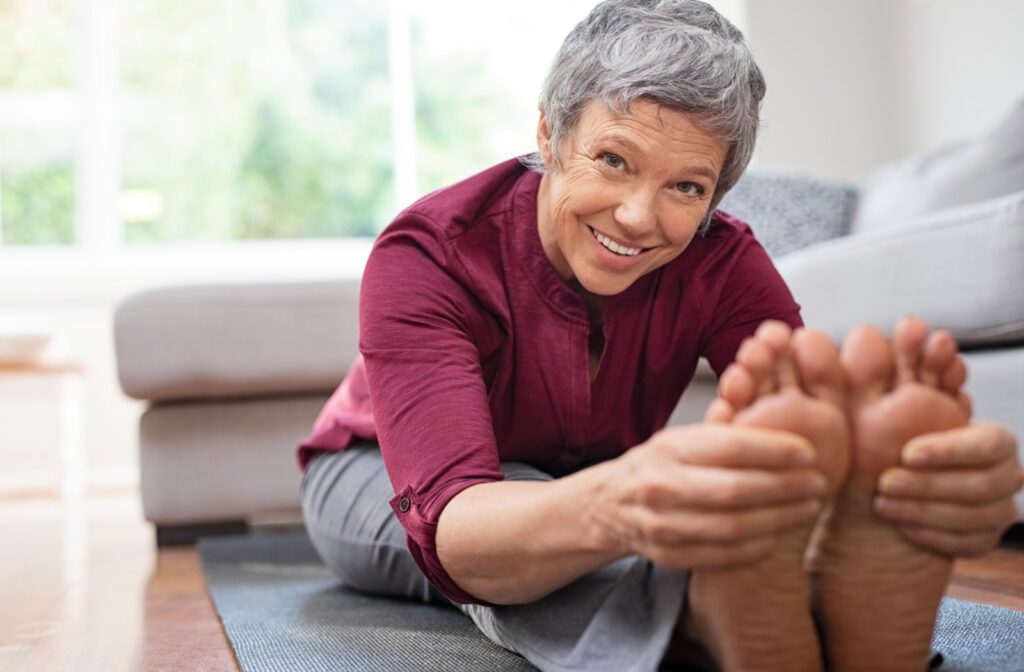 A close-up of a senior woman stretching and grabbing her feet.