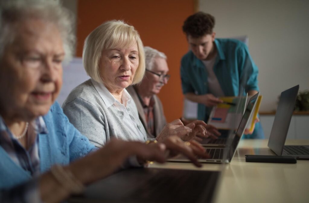 A group of seniors take a class through memory care on computer literacy to learn new skills and keep their minds sharp