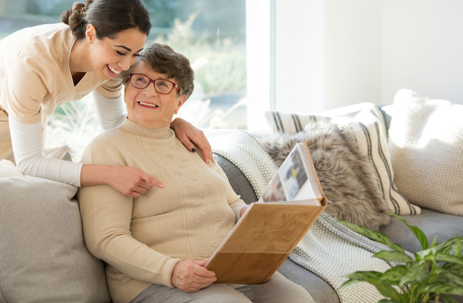 a senior showing a photo album to a caregiver