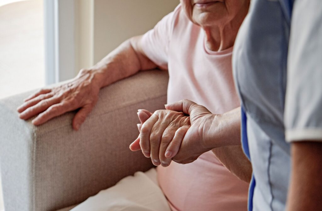 a caregiver supporting a senior to get up